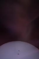 Солнце через солнечный фильтр. На самом деле выглядит белым (с пятнами) на чёрном фоне. Красный оттенок - это просто засветка фотоаппарата сбоку.