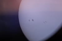 Солнце через солнечный фильтр. На самом деле выглядит белым (с пятнами) на чёрном фоне. Красный оттенок - это просто засветка фотоаппарата сбоку.